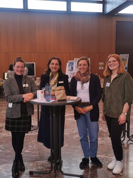 Vier Frauen stehen um einen Tisch herum.