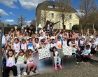 Eine Gruppe von Kindern winkt in die Kamera.