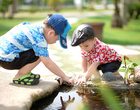 Zwei kleine Jungs spielen im Freien an einem Teich.