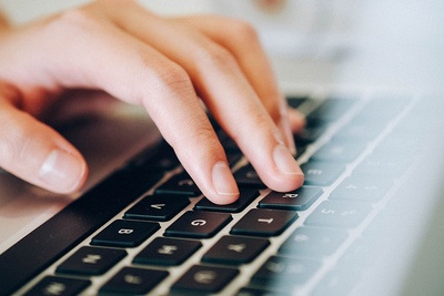 Finger tippen auf einer schwarzen Computertastatur