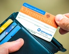 eine Hand hält ein Portemonnaie und einen Organspendeausweis