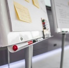 Zwei Moderationstafeln, an denen Notizzettel kleben und bunte Stifte liegen.