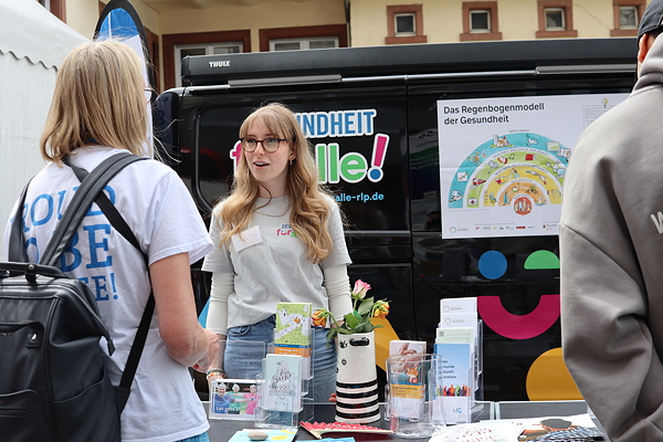 Eine Frau informiert sich am Stand von "Gesundheit für alle"